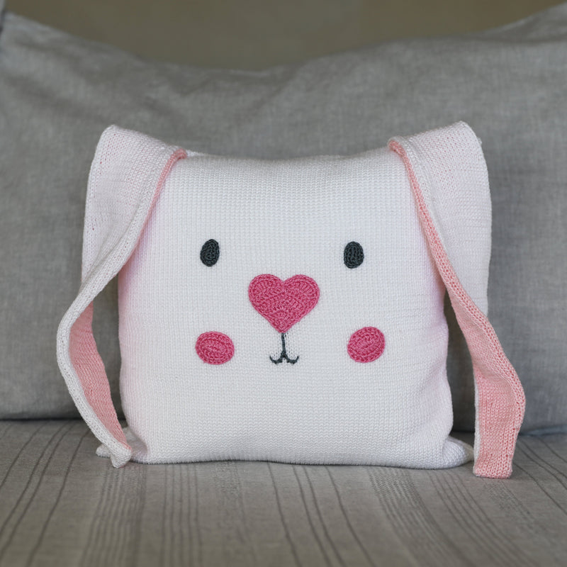 Load image into Gallery viewer, Knitted pillow with a bunny face design on a gray background
